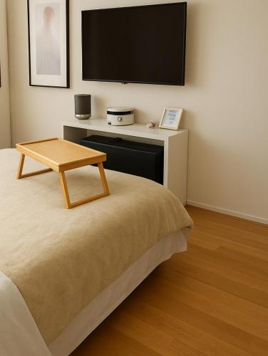 a room with a bed with a tv on the wall at PepinA'S Home in Martigny-Ville