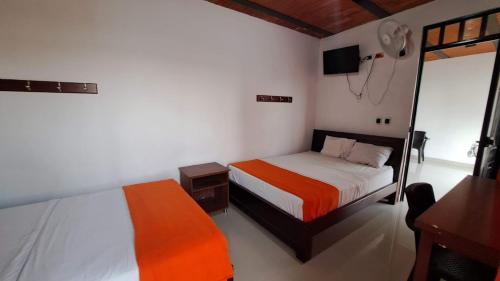 a bedroom with two beds and a television in it at Hotel Rios in Garzón