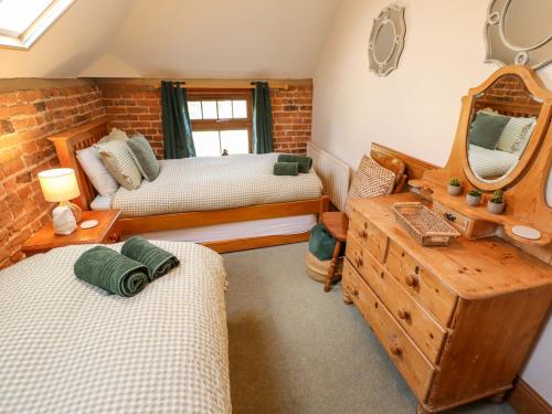 a bedroom with two beds and a mirror at Barn Owl in Louth