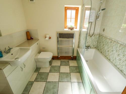 a bathroom with a tub and a toilet and a sink at Barn Owl in Louth