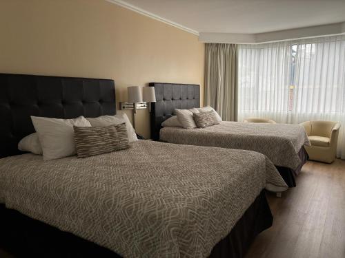 a hotel room with two beds and a window at Taormina Hotel y Casino in San José