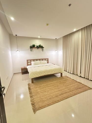 a bedroom with a bed and a rug at Bohovibes in Buraydah