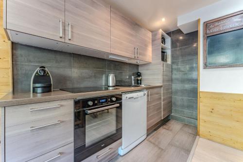 a kitchen with a stove and a dishwasher at Spacious Ski-In Out apartment with Mountain Views in Val Thorens