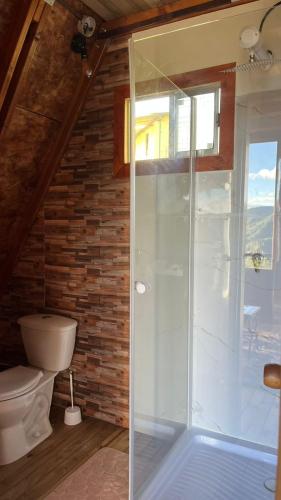 a bathroom with a toilet and a glass shower at Tierra Viva By Astrid in Cucunubá