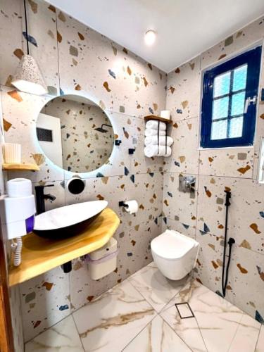 a bathroom with a toilet and a sink and a mirror at Creta Star Apartments in Agia Galini