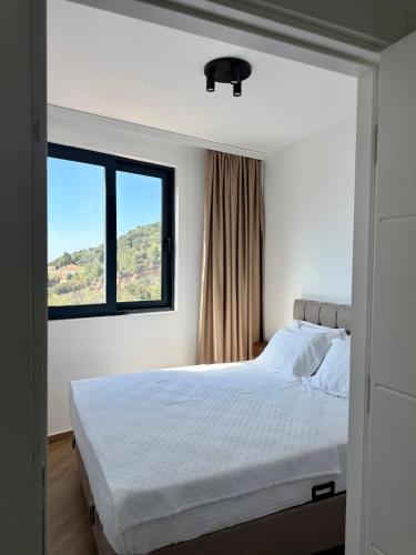 a bedroom with a white bed with a window at Maresa 7 in Čanj