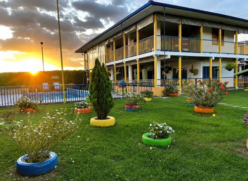 a building with plants in front of a yard at Finca Hotel Vista Palmar - Eje Cafetero in Quimbaya