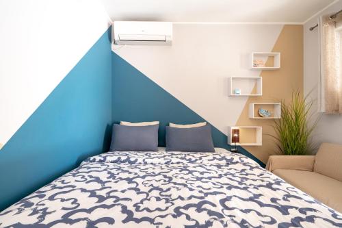 a blue and white bedroom with a bed and a chair at Artemis Boutique House in Artemida