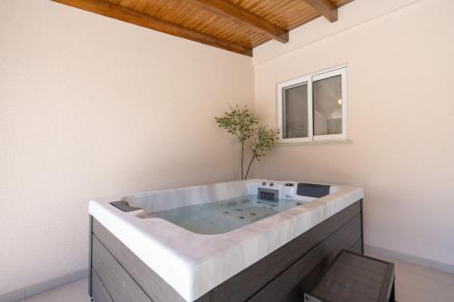 a large bath tub in a room with a window at Artemis Boutique House in Artemida