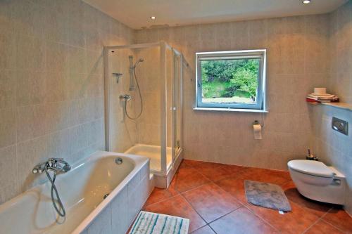 a bathroom with a tub and a toilet and a shower at 3 Bed in Inch oc-i444 in Caheracruttera