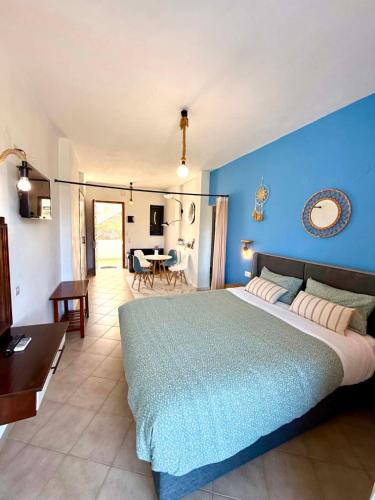 a bedroom with a large bed with a blue wall at Creta Star Apartments in Agia Galini