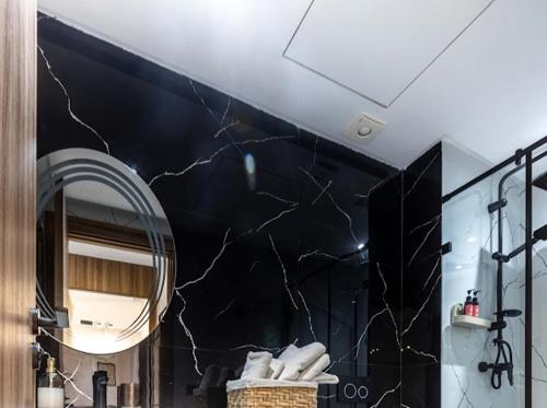 a bathroom with a black wall and a mirror at Arena Maarif 41 in Maarif