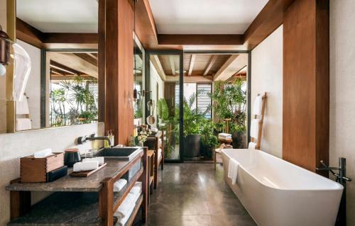 a bathroom with a large tub and a sink at Rosewood Mayakoba in Playa del Carmen