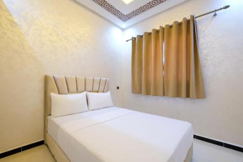 a white bed in a room with a curtain at Riad Bollywood-Golden Stay D in Benguerir