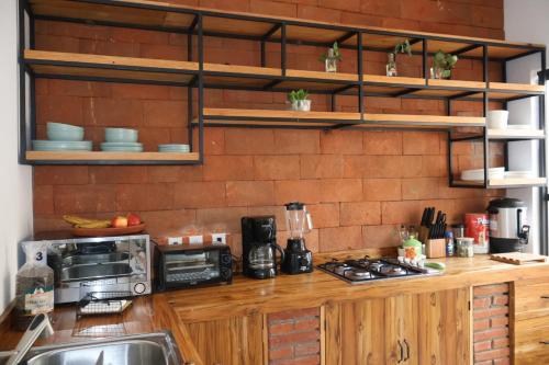 a kitchen with a counter with a microwave and a sink at Hotel Ladrillo in Oaxaca City