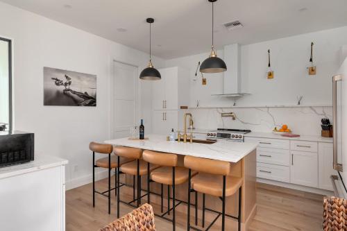 a kitchen with white cabinets and a kitchen island with bar stools at Spacious home private pool patio & bbq in Vero Beach