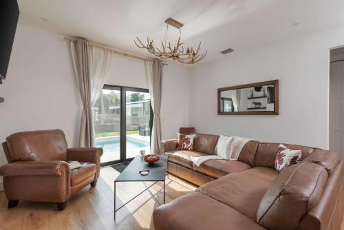 a living room with a couch and chairs and a chandelier at Spacious home private pool patio & bbq in Vero Beach