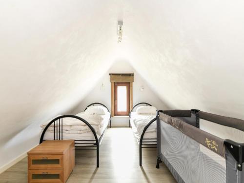 a attic bedroom with two bunk beds and a window at Floribert in Nieuwpoort-Bad