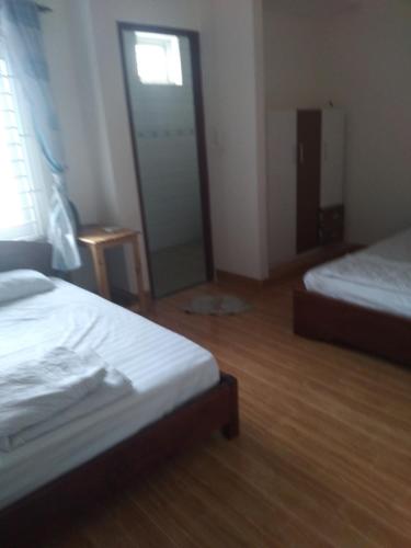 a bedroom with two beds and a glass door at Quyenhomestay in Cù Lao Tâu