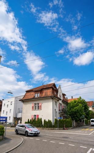 a car parked in front of a building on a street at Bern Garden Residence 152m Luxury Apartment in Bern