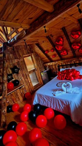 a room with a bed with red and black balloons at Quinta La Primavera Ecolodge in Isnos