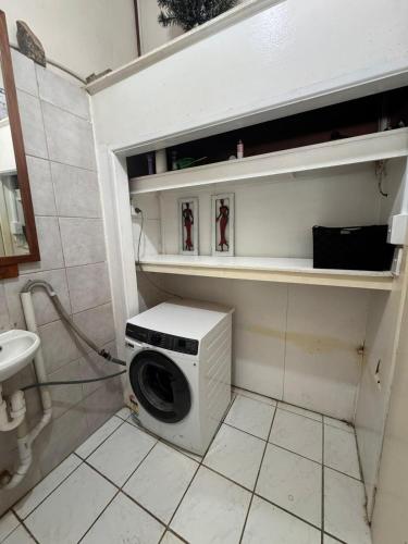 a washer and dryer in a small bathroom at Mama Cat's Accommodation in Avarua