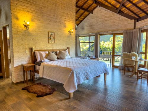 a bedroom with a large bed in a room at Estalagem Mandeville in Monte Verde