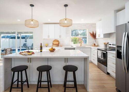 a kitchen with white cabinets and a island with bar stools at Sweet Serenity-Private Pool-8 Mins to Old Town in Scottsdale