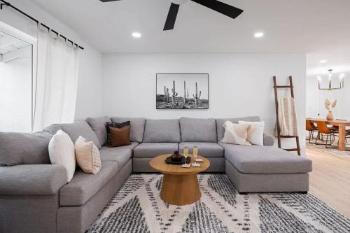 a living room with a gray couch and a table at Sweet Serenity-Private Pool-8 Mins to Old Town in Scottsdale
