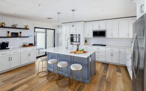 a kitchen with white cabinets and a island with bar stools at Old Town Art Deco - Pool&Fire Pit - In Old Town in Scottsdale