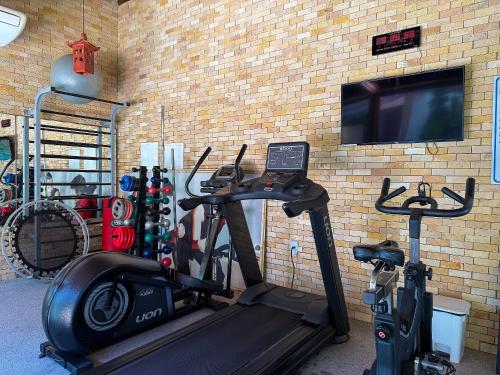 a gym with a wall with a tv and a treadmill at Villas de Samoa - House with 4 bedrooms in Cabedelo