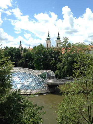 a bridge over a river with a building in the background at Apartment Graz Murpromenade in Graz