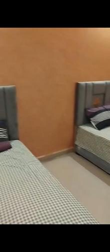 two beds sitting next to each other in a bedroom at بوخالف طنجة Youssef Residence in Tangier