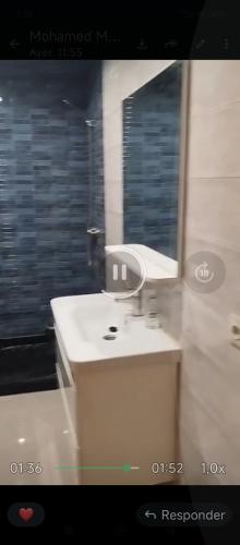 a bathroom with a white sink and a mirror at بوخالف طنجة Youssef Residence in Tangier
