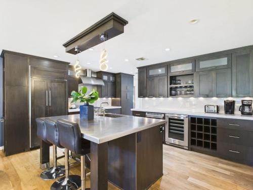 a kitchen with wooden cabinets and a large kitchen island at Azure - Sparkling Pool - Pool Table - In Old Town in Scottsdale