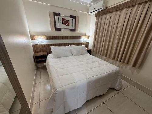 a bedroom with a large white bed in a room at Lacqua diRoma in Caldas Novas