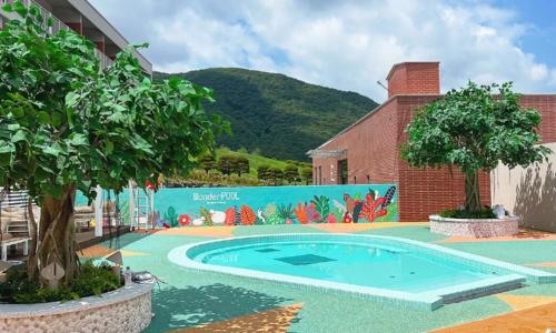 a swimming pool with a mural on the side of a building at Belle Fore Resort in Jeungpyeong