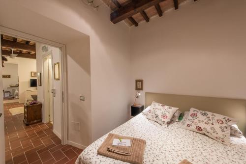 a bedroom with a bed with pillows on it at Vermaaten Boutique Suites Emerald in Todi