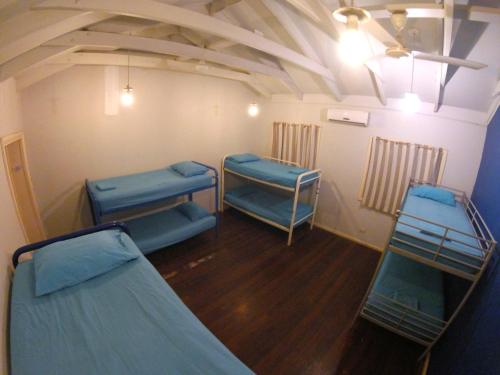 a room with three bunk beds and a ceiling at Cable Beach Backpackers in Broome