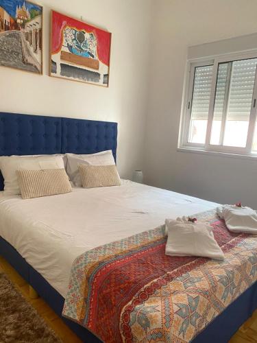 a bed with a blue headboard in a bedroom at Quinta das Rosas - Beach 500m away in Figueira da Foz
