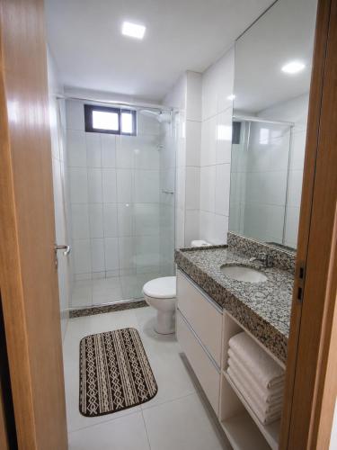 a bathroom with a shower and a toilet and a sink at Paiva Ocean View - 17th Floor with Pool, Sauna & Jacuzzi in Recife