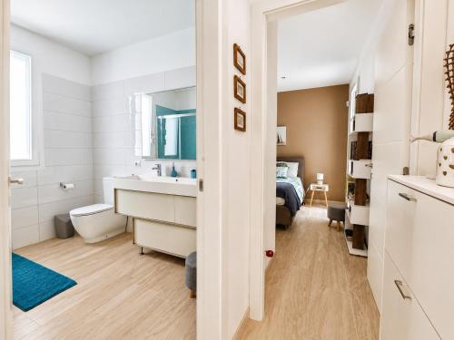 a white bathroom with a sink and a bed at Villa Dolce Vita in Triscina