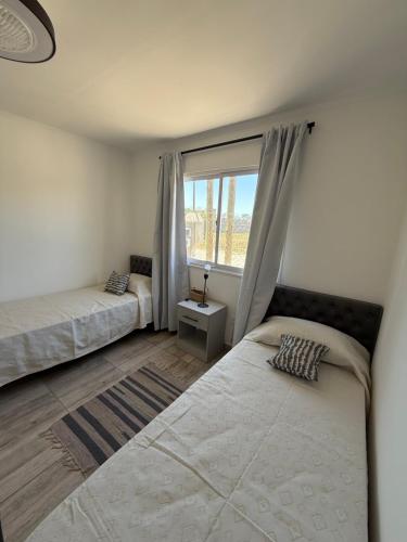 a bedroom with two beds and a window at Las Magnolias CABAÑAS in Salta
