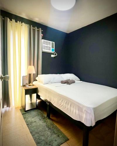 a bed in a bedroom with a blue wall at 2BR Italian-inspired Condo Unit, Balcony Pool View in Manila