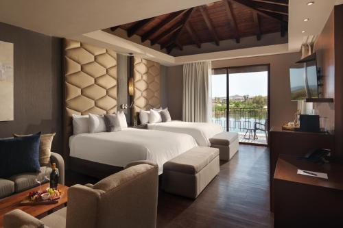 a hotel room with two beds and a balcony at El Cielo Resort in Valle de Guadalupe
