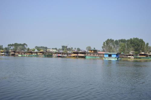 a group of houses on the banks of a river at Lake Palace Group Of House Boats in Srinagar