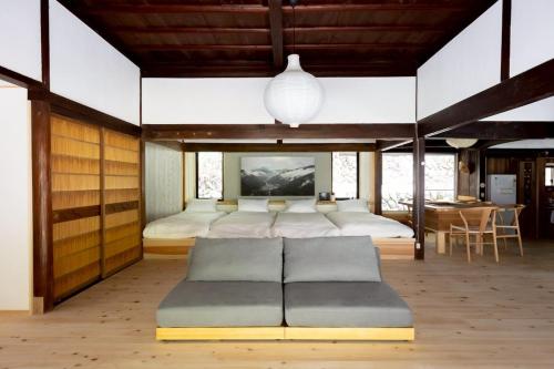 a bedroom with four beds and a couch in it at Nagi no Ne in Washika