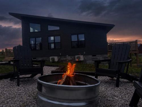 a fire pit with two chairs and a house at Spruce Arch - King Bed Fireplace Pets Welcome in Rogers