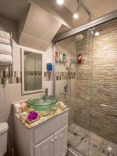 a bathroom with a sink and a glass shower at Sea Castles La Vue in Montego Bay