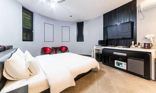 a bedroom with a bed and a flat screen tv at Paju Picasso in Paju
